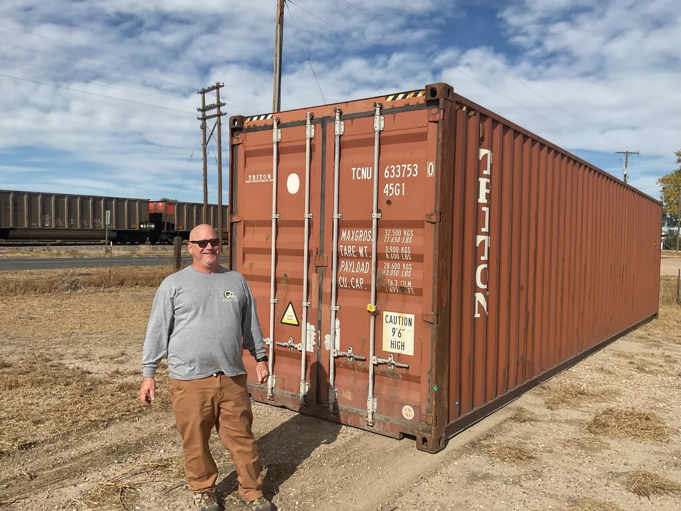 Shipping container delivered beside a rail yard