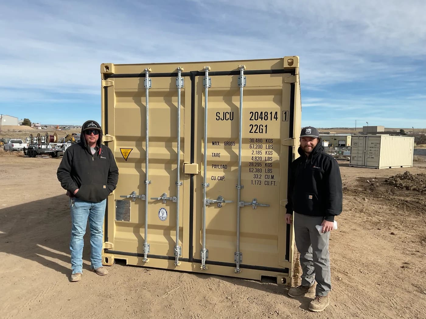 Freedom Conex team members in front of a shipping container