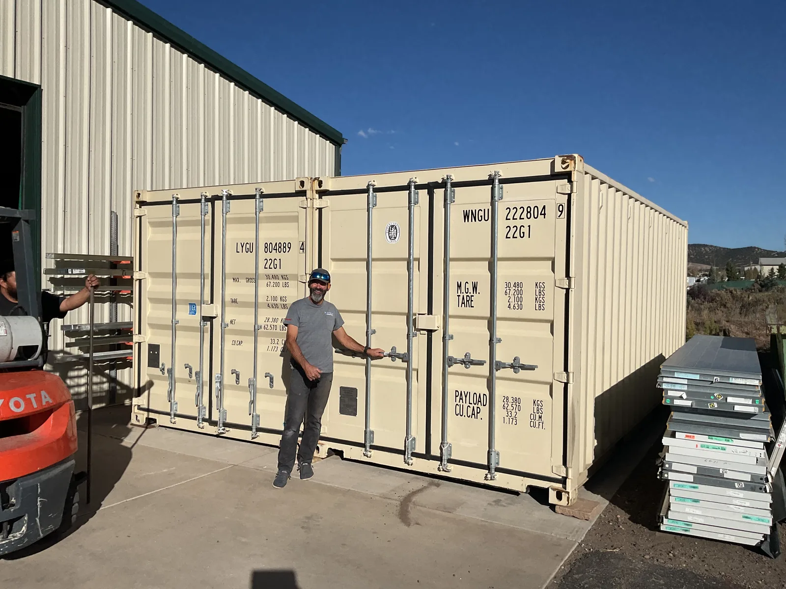 Freedom Conex team member with a shipping container at the yard