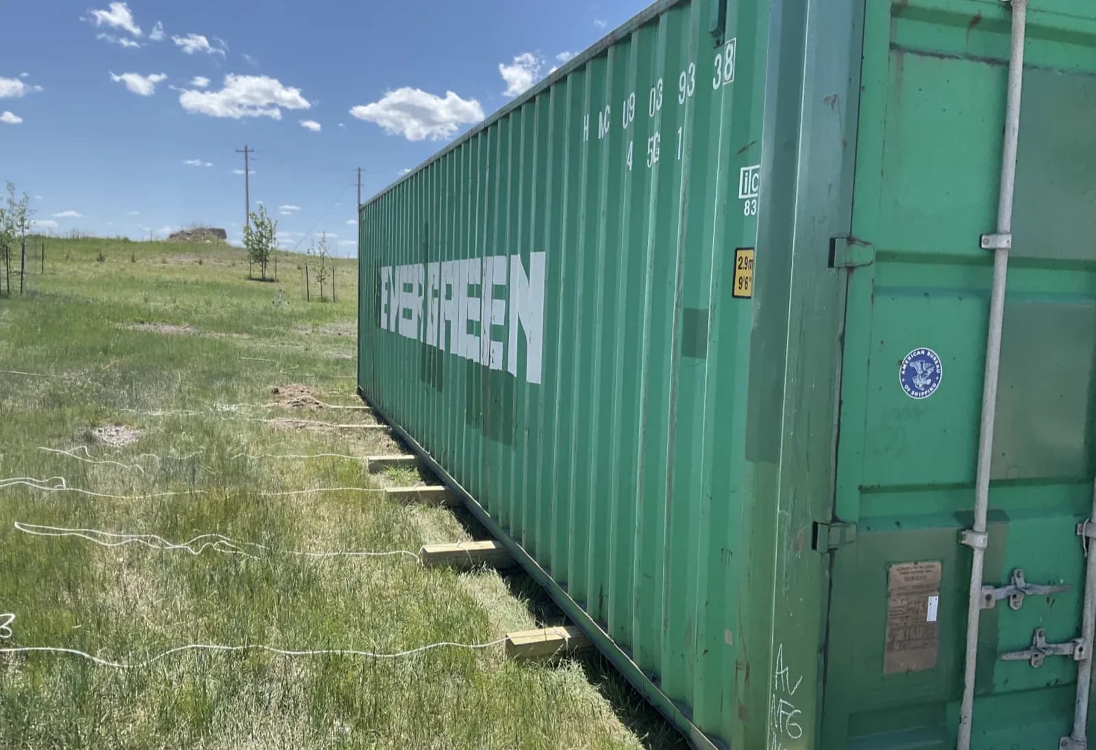 Shipping container set on evenly spaced wood beams