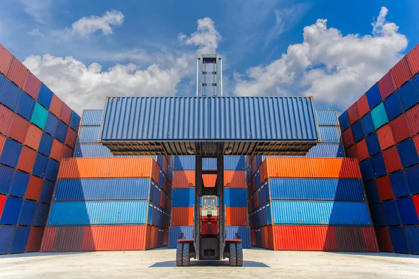 Reach stacker lifting a shipping container at a container yard